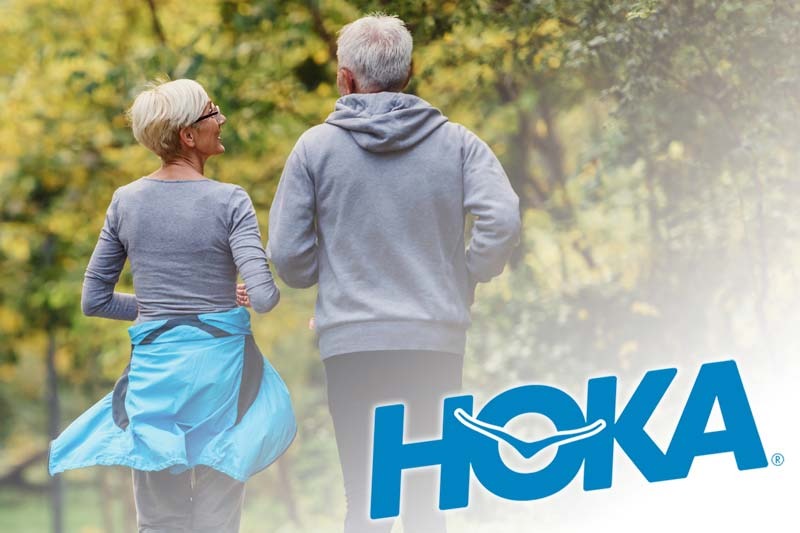 Elderly Couple Running through a Park with HOKA logo overlaid