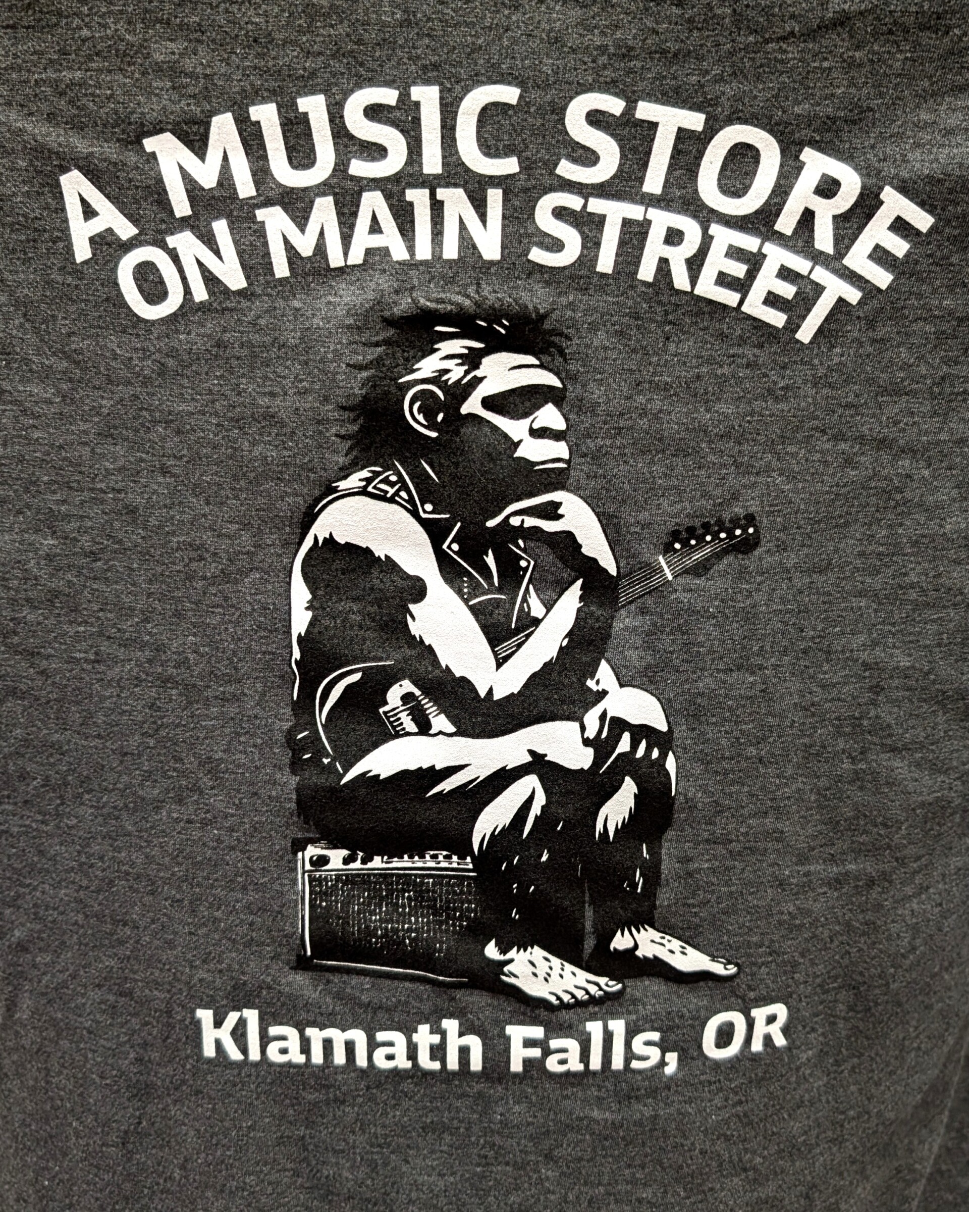 A Music Store on Main Street Tri-Blend T-Shirt, Neanderthal Rocker, Various Colors/Sizes