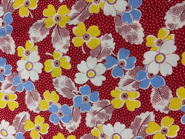 Feedsack Reproduction -blue and yellow flowers over white dot on red 