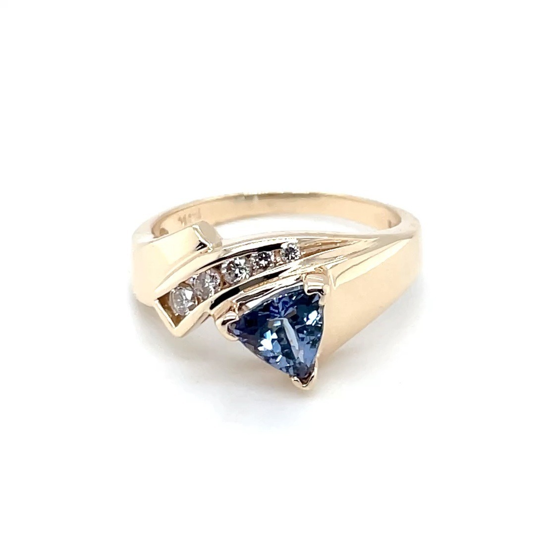 Tanzanite trilliant cut fashion ring with .15ct. T.W. of natural brilliant round cut diamonds SI1 clarity, G color set in 14k yellow gold.