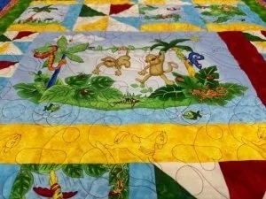 red and yellow, green jungle animals quilt with half sqaure yellow, grren and red squares.