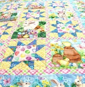 easter quilt with colored easter eggs and bunny rabbits participating in an easter egg hunt.