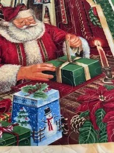santa claus wrapping a green box for christams, has ablue box with a piece of holly as a bow, another grren box with a candy cane tied on with a red ribbon,