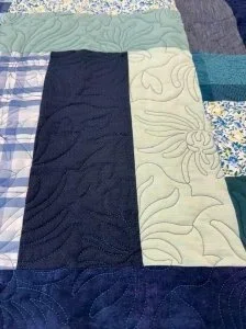 teal, blue, blue stripped and pieces of dress shirts making up this memory quilt. 