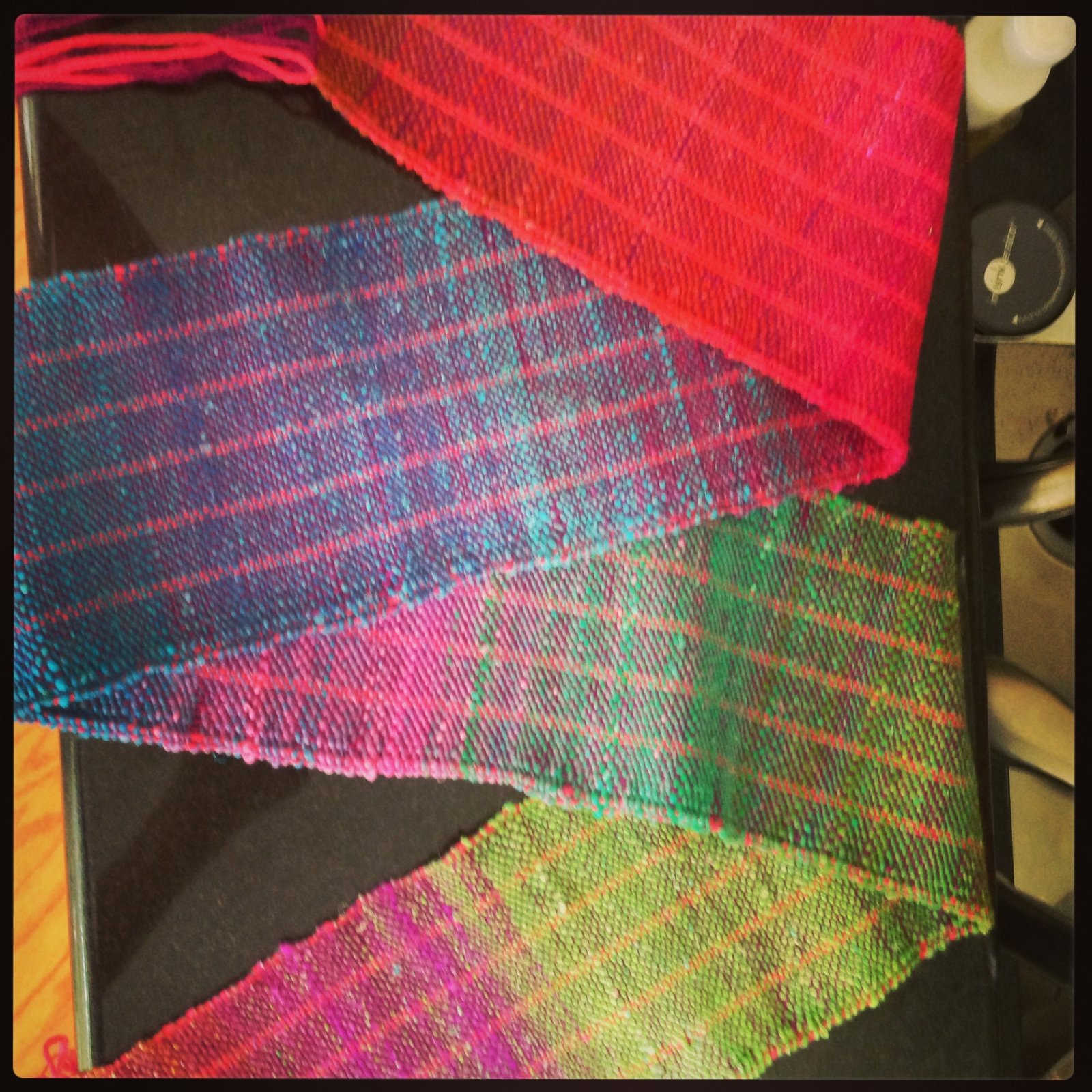 a multicolored handwoven scarf in jewel tones draped elegantly 