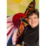 Mary Ellen Winter in front of the Monarch Legit Kits quilt